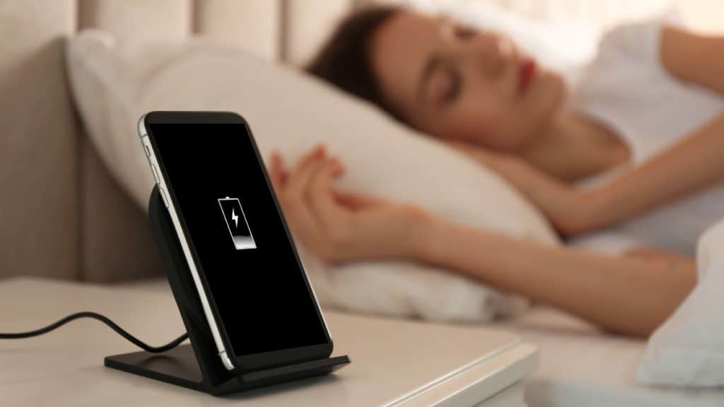 phone charging nearby woman's bed